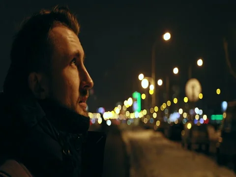 4K Side view. Young man enjoying the fresh air in the city at night. Stock Footage 73054684