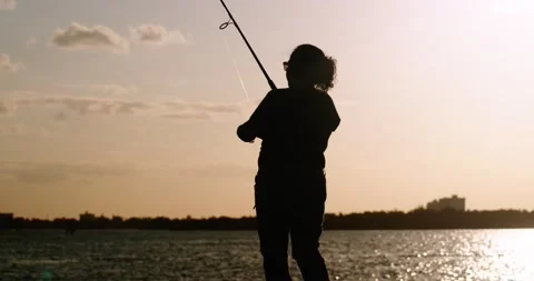 4K Silhouette of Latina woman fishing against pretty sunset.  4K footage. Stock Footage