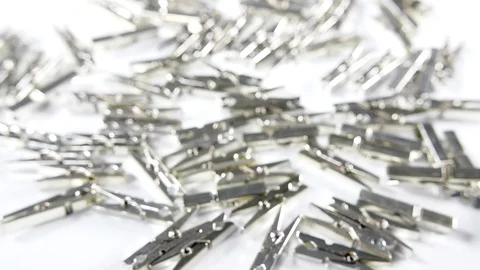4k silver metallic pegs scattered on a white surface background. Craft scrap Stock Footage 90824515