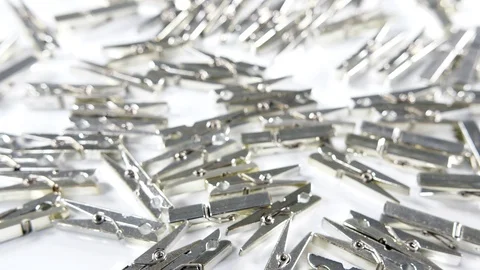4k silver metallic pegs scattered on a white surface background. close up image Stock Footage 90825058