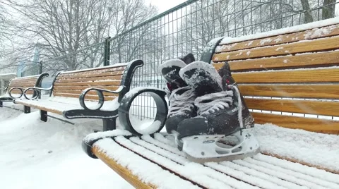 4k skates on bench while it snows side pan Stock Footage 61202221