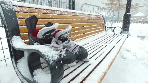 4k skates on bench while it snows Stock Footage 61203110