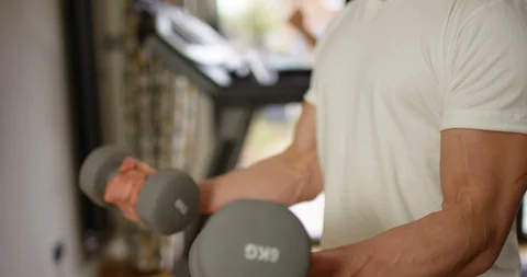4K Slim but muscular man working out, lifting dumbbell weights at the gym	 Stock Footage