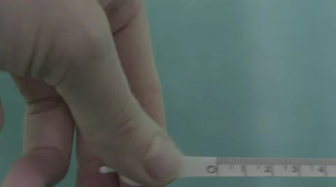 4K Slog2 pulling white metal measuring tape across green background Stock Footage 56726738