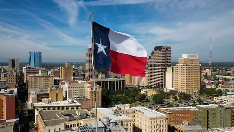 4K Slow Drone Orbit of Texas State Flag with San Antonio Skyline in Background Stock Footage 119718774