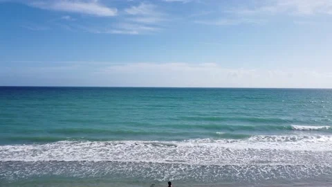 4k slow fly over beach towards ocean in florida beach on a sunny day Stock Footage 233939525