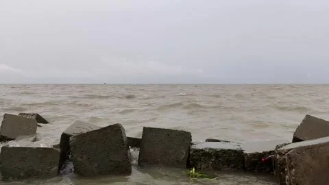 4K Slow Left to Right Pan of River Waves Hitting Concrete Shoreline Stock Footage 338401709