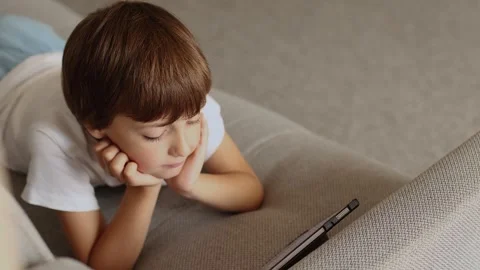 4K slow motion 60fps footage of a cute young boy lying on a comfortable couch Stock Footage 344438233