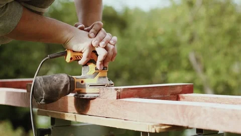 4K slow motion of a carpenter sanding a wooden beam with an electric sander. Stock Footage 344880922