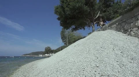 4K Slow motion child runs down pebble heap Stock Footage 64069716