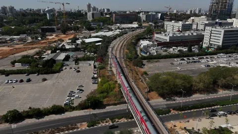 4K slow motion cinematic drone tracking a long red passenger train entering Stock Footage 336883312