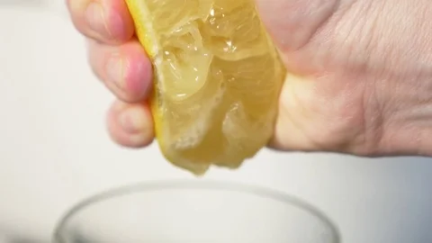 4k, slow-motion, close-up. hand compressing lemon. squeeze out lemon juice Stock Footage 84160483