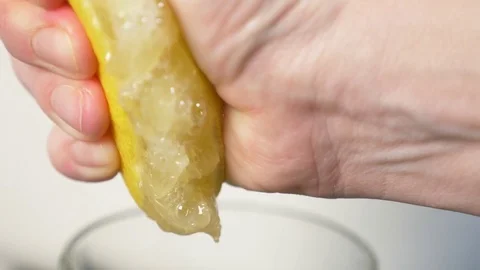 4k, slow-motion, close-up. hand compressing lemon. squeeze out lemon juice Stock Footage 84160615