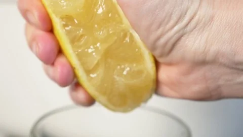 4k, slow-motion, close-up. hand compressing lemon. squeeze out lemon juice Stock Footage 84199511