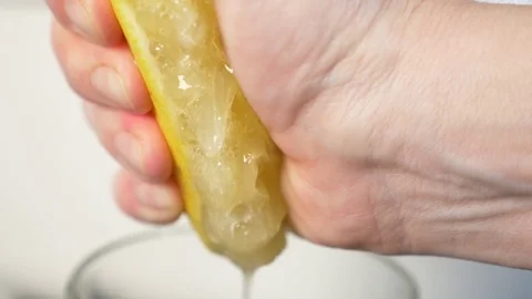 4k, slow-motion, close-up. hand compressing lemon. squeeze out lemon juice Stock Footage 84199797