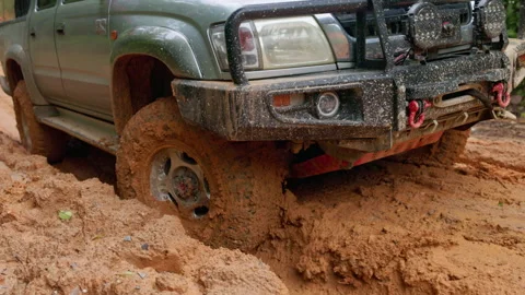 4K slow motion closeup of offroad truck wheel spinning and splashing mud. D.. Stock Footage 337805324