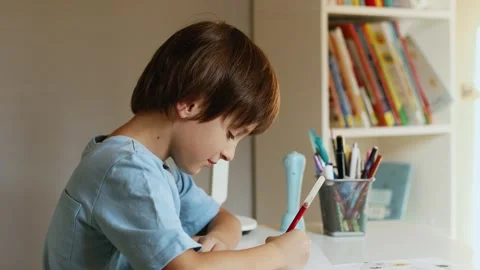 4K slow motion of a focused little boy writing with a felt tip pen at a desk. 스톡 동영상 346069118
