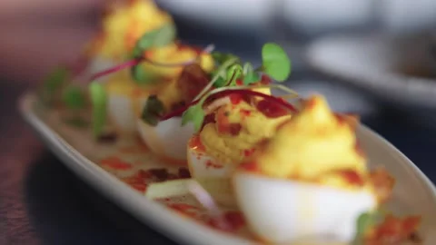 4K slow motion footage of delicate deviled eggs topped with microgreens served Stock Footage 332137113