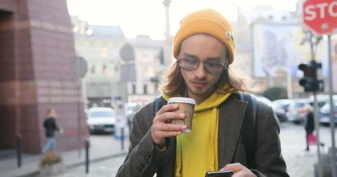 4k. Slow motion. Freelancer or student in the town. Handsome young man in yellow Stock Footage 98347365