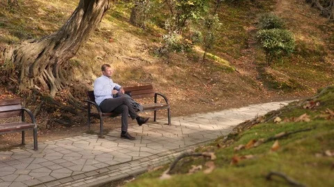 4k, slow motion. the guy sitting on the bench notices the shadowing after Stock Footage 81928932