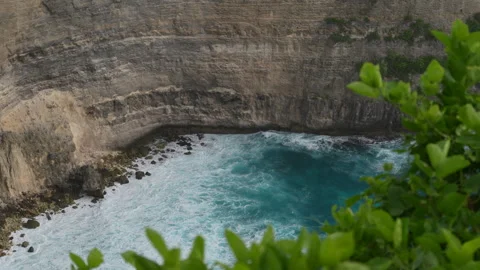 4K slow motion high angle view of ocean waves crashing against a cliff wall 스톡 동영상 337088157