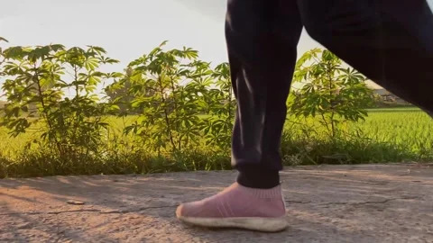 4K Slow Motion Low Angle Shot of a Person Pacing Through Nature on a Rural Road Stock Footage 337984162