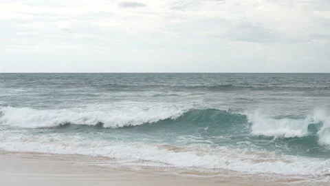 4K slow motion of a powerful turquoise wave curling on a sandy beach 스톡 동영상 337087217