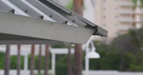 4K Slow Motion Rain Dripping onto and off of metal roof during storm Stock Footage 251024462
