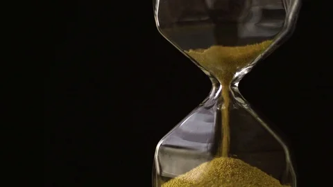 4k slow motion ,The sand flow in the hourglass with black background Stock Footage 99598034