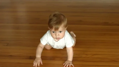 4K slow motion shot of a cute baby boy crawling toward the camera Stock Footage 121636627