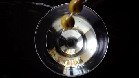 4k, Slow motion shot of olive splashing into martini, top view Stock Footage 113514129