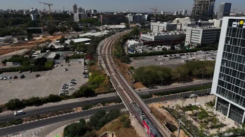 4K slow motion static drone shot of a red passenger train entering Rehovot Stock Footage 336814115