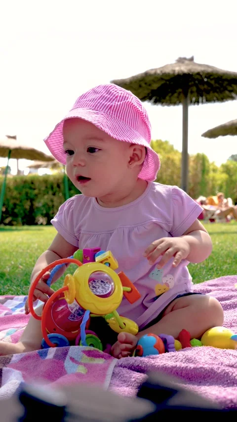4k slow motion vertical video of a smiling baby sitting on a towel in a pool Stock Footage 218965001