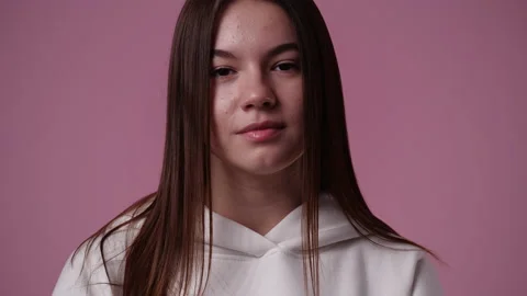 4k slow motion video of blank emotion of one girl on pink background. Video stock 227411174