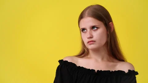 4k slow motion video of blank emotion of one girl on yellow background. Stock Footage 229129075