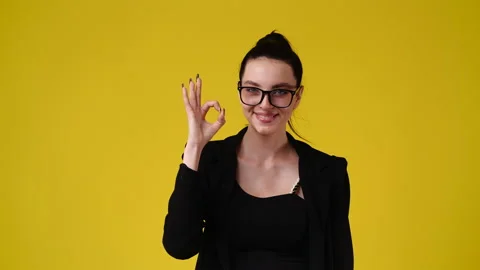 4k slow motion video of cute girl showing OK sign on yellow background. Stock Footage 227414792