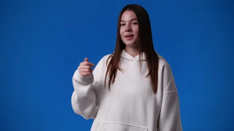 4k slow motion video of cute girl pointing at left and showing thumb up over Video stock 227511605
