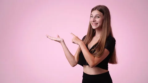4k slow motion video of cute girl pointing at left and showing thumb up over Stock Footage 228403060