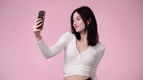 4k slow motion video of cute girl using phone over pink background. Stock Footage 228720017