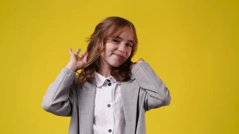 4k slow motion video of cute girl smiling over yellow background. Video stock 229714015