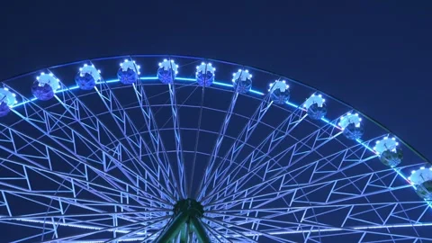 4K slow motion video of ferris wheel illuminating at an amusement park at night. Stock Footage 327556550