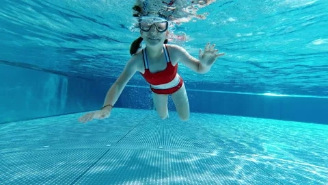4K slow motion video of funny little girl having fun under water in swimming Stock Footage 201352969