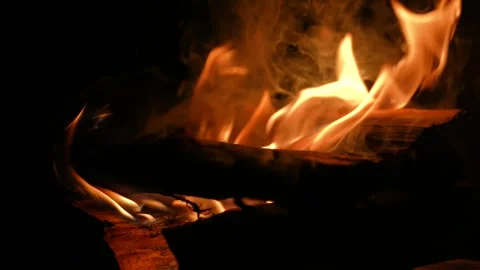 A 4K slow motion video of logs burning with orange flames at a braai Stock Footage 260116032