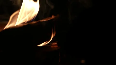 A 4K slow motion video of logs burning with orange flames at a braai Stock Footage 260116036