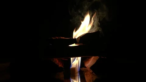 A 4K slow motion video of logs burning with orange flames at a braai Stock Footage 260116043