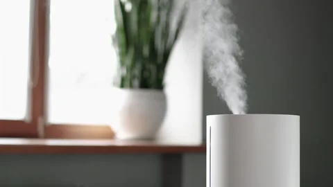 4K slow motion video of modern ultrasonic humidifier releasing steam in brigh Stock Footage 328221208