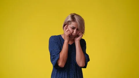 4k slow motion video of one girl having headache over yellow background. Stock Footage 227237170