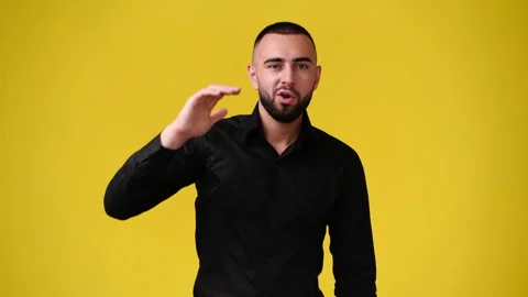 4k slow motion video of one man looking at the camera over yellow background. Stock Footage 227405715