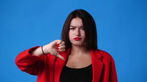 4k slow motion video of one girl showing thumb down on blue background. Stock Footage 227406658