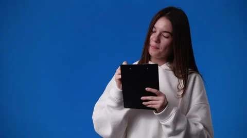 4k slow motion video of one girl with note pad over blue background. Stock Footage 227413873